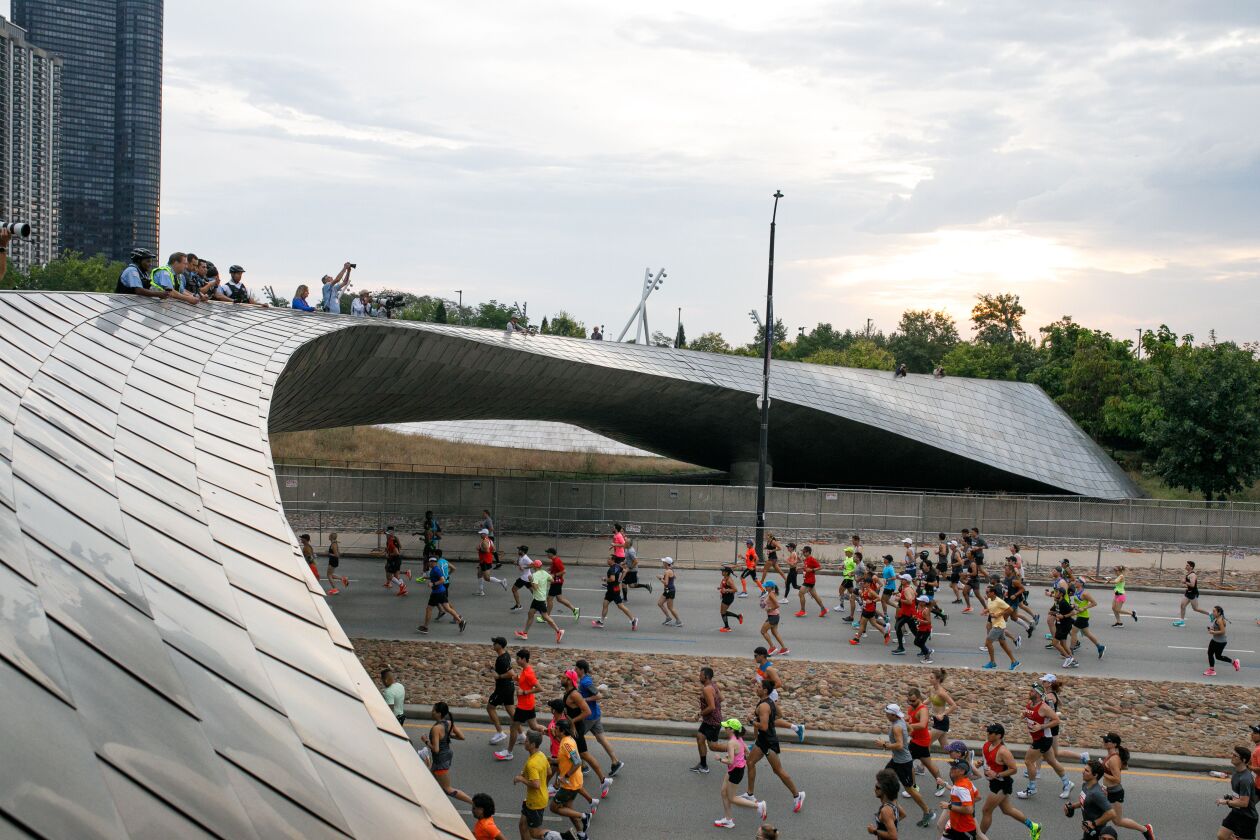 Runners in the Chicago Marathon head north on Columbus Drive, under the BP Pedestrian Bridge connecting Maggie Daley and Millennium parks, on Sunday, Oct. 10, 2021.